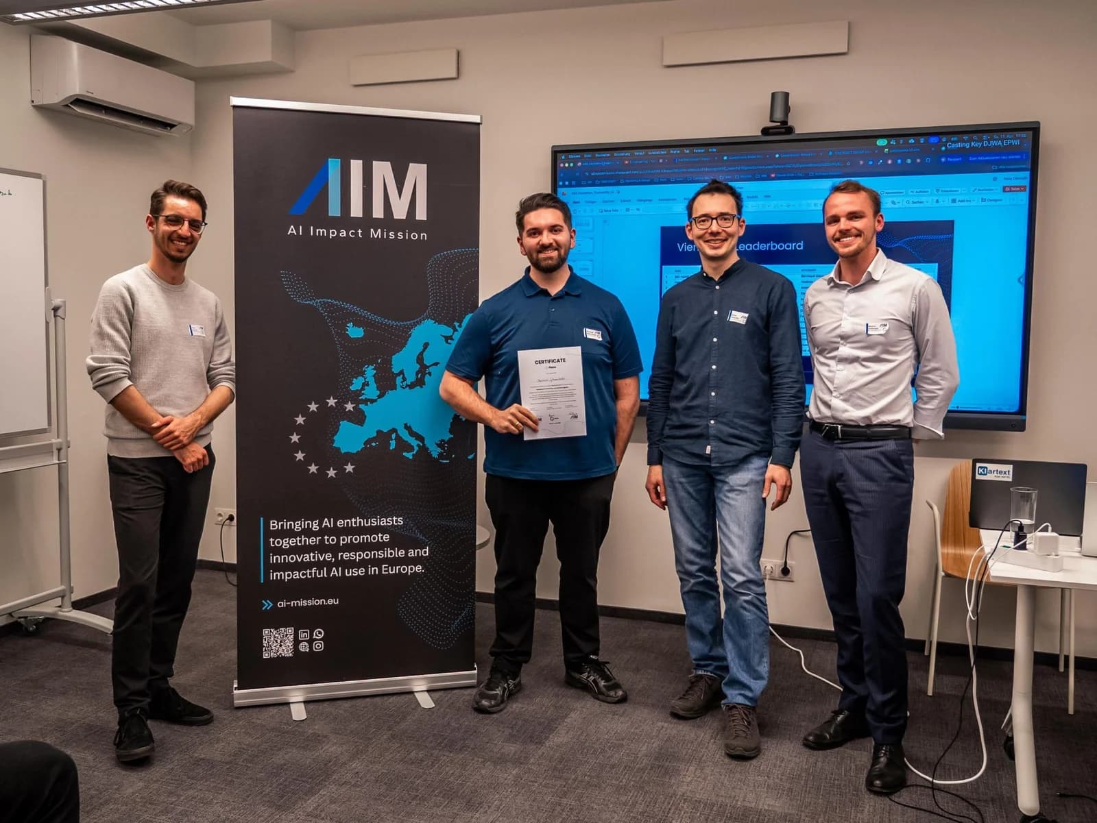 Bernhard Götzendorfer, second from left, holding the BitGN PAC Hackathon certificate at the AI Impact Mission roll-up.