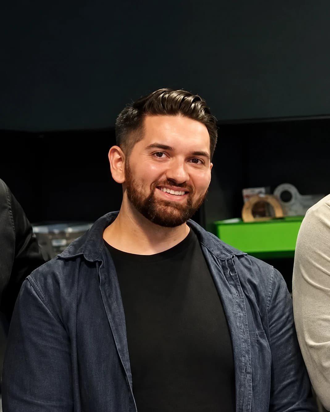 Bernhard Götzendorfer im dunklen Hemd über schwarzem Shirt, sitzend beim Panel des Wien Software Architecture Meetup, lächelt Richtung Publikum.